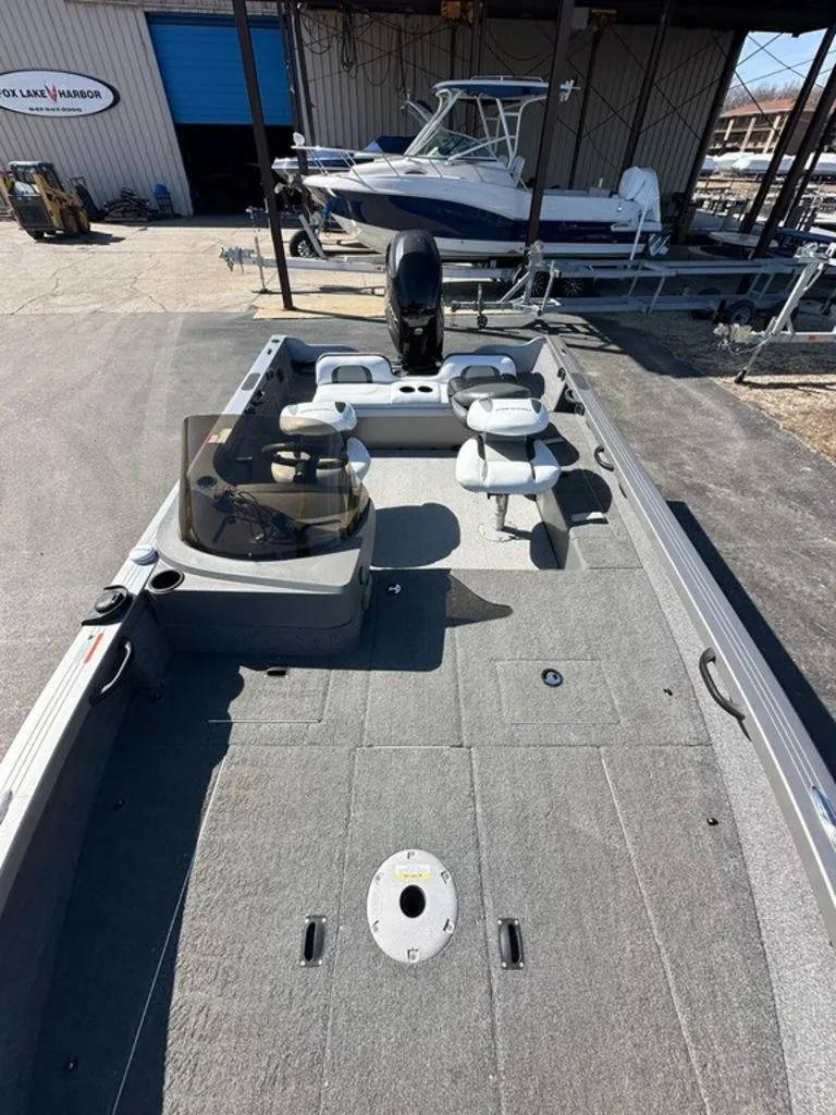 Slide: The Image of 2013 Crestliner Fish Hawk 1750 boat with spacious deck and seating, parked at marina. - 7