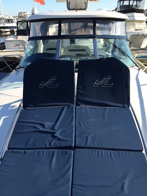 Slide: The Image of 2010 Sea Ray 390 Sundancer with blue sun pads on deck, docked at marina. - 13