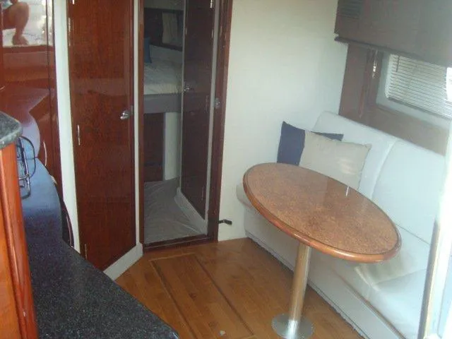 Slide: The Image of Interior of 2010 Sea Ray 390 Sundancer with wooden table and white seating. - 14