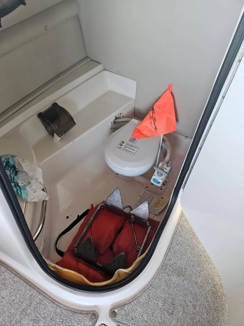 Slide: The Image of 2003 Chaparral Sunesta 263 boat interior with toilet, anchor, and safety equipment. - 12