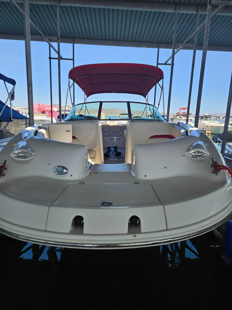 Slide: The Image of 2003 Chaparral Sunesta 263 boat with red canopy docked under a covered marina. - 4