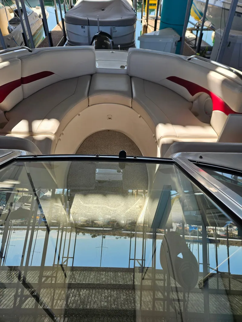 Slide: The Image of 2003 Chaparral Sunesta 263 boat interior with beige seating and red accents. - 7