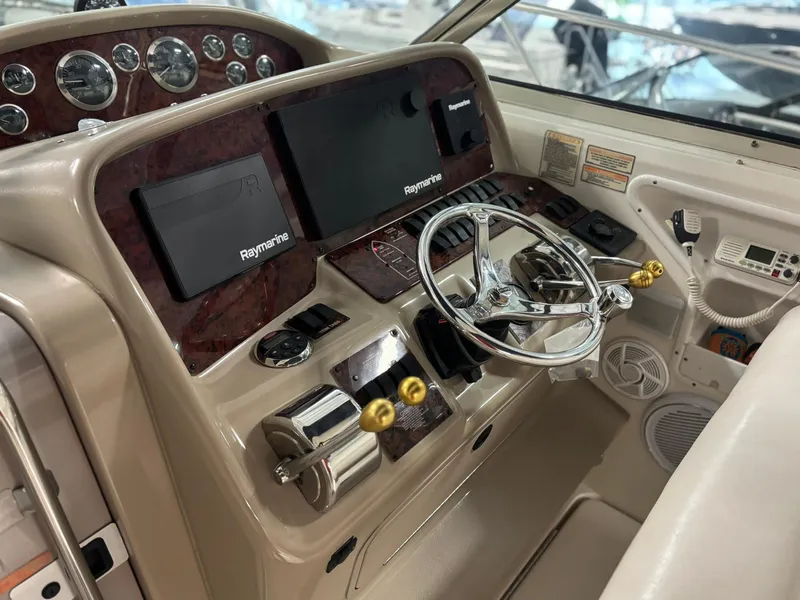 Slide: The Image of 1999 Sea Ray 370 Express Cruiser helm with Raymarine displays and chrome steering wheel. - 10