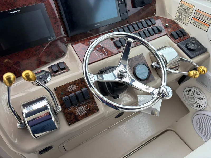 Slide: The Image of 1999 Sea Ray 370 Express Cruiser helm with steering wheel and control panel. - 11