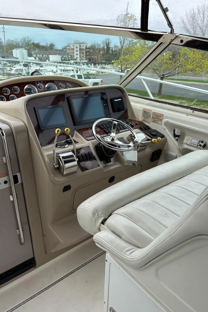 Slide: The Image of 1999 Sea Ray 370 Express Cruiser helm with modern navigation equipment and comfortable seating. - 12