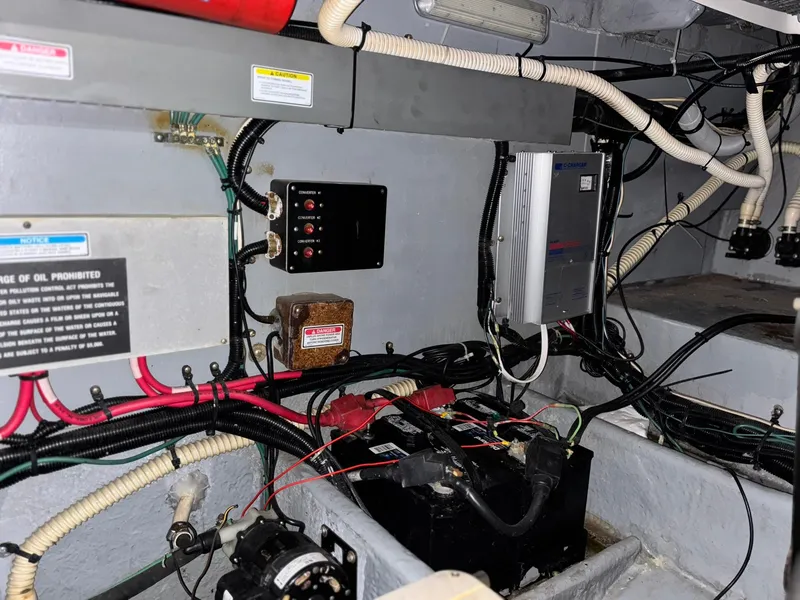 Slide: The Image of Engine room of 1999 Sea Ray 370 Express Cruiser with wiring and battery components. - 16
