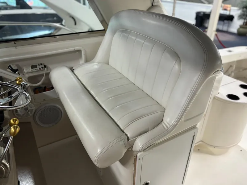 Slide: The Image of 1999 Sea Ray 370 Express Cruiser helm seat, white leather, with steering wheel and controls. - 18
