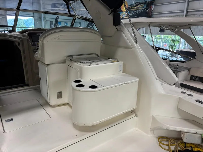 Slide: The Image of 1999 Sea Ray 370 Express Cruiser interior with seating and storage in a showroom. - 24
