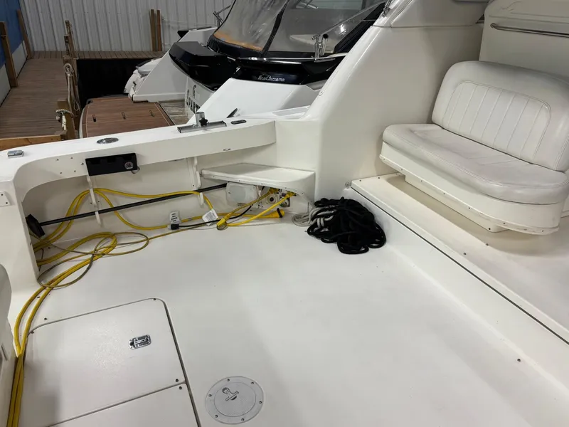 Slide: The Image of 1999 Sea Ray 370 Express Cruiser interior with seating and docked boat view. - 26