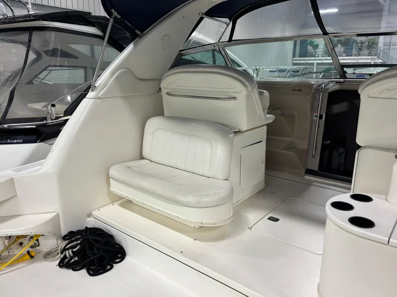 Slide: The Image of 1999 Sea Ray 370 Express Cruiser interior with white seating and cup holders. - 27