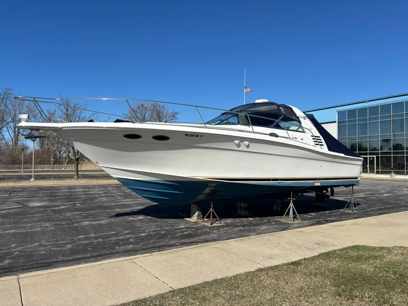Slide: The Image of 1999 Sea Ray 370 Express Cruiser on stands, outdoors, under clear blue sky. - 3