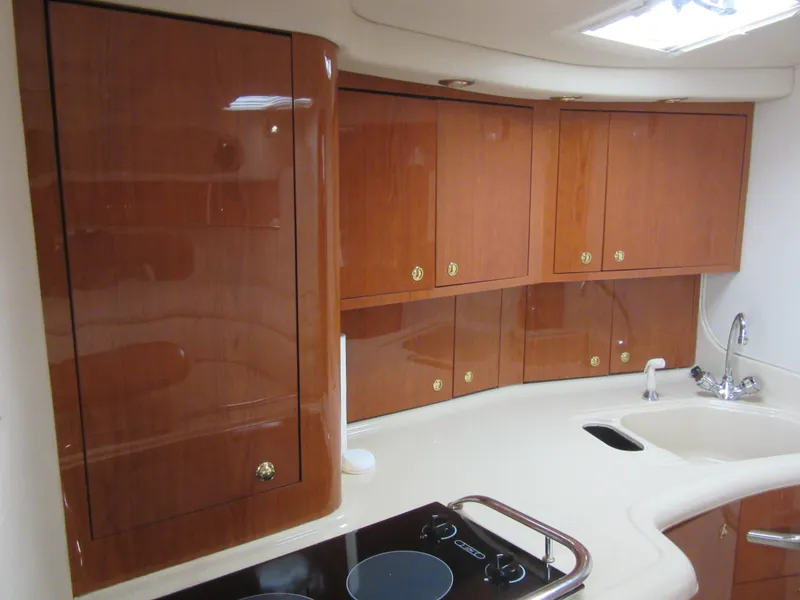 Slide: The Image of 1999 Sea Ray 370 Express Cruiser kitchen with wooden cabinets and modern appliances. - 34