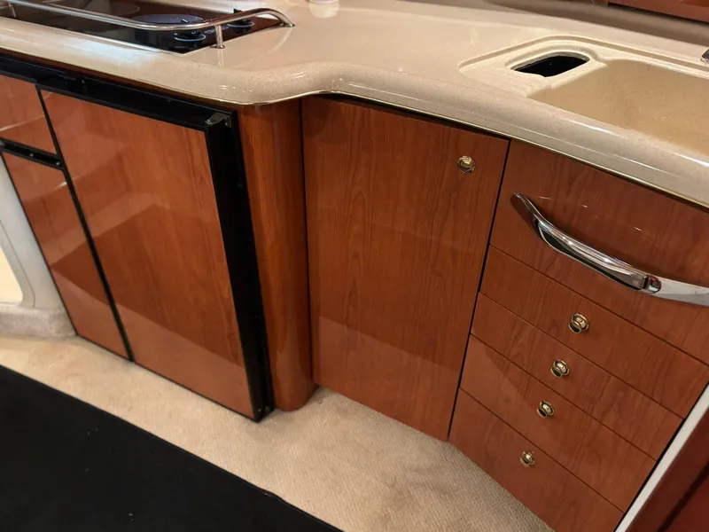 Slide: The Image of Interior of 1999 Sea Ray 370 Express Cruiser with wood cabinetry and compact kitchen area. - 35