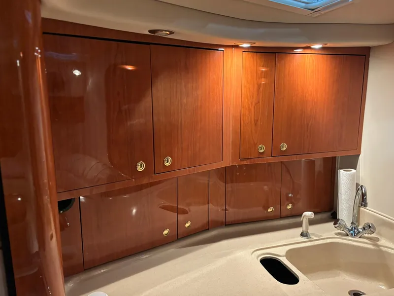 Slide: The Image of 1999 Sea Ray 370 Express Cruiser interior with wooden cabinets and sink. - 37