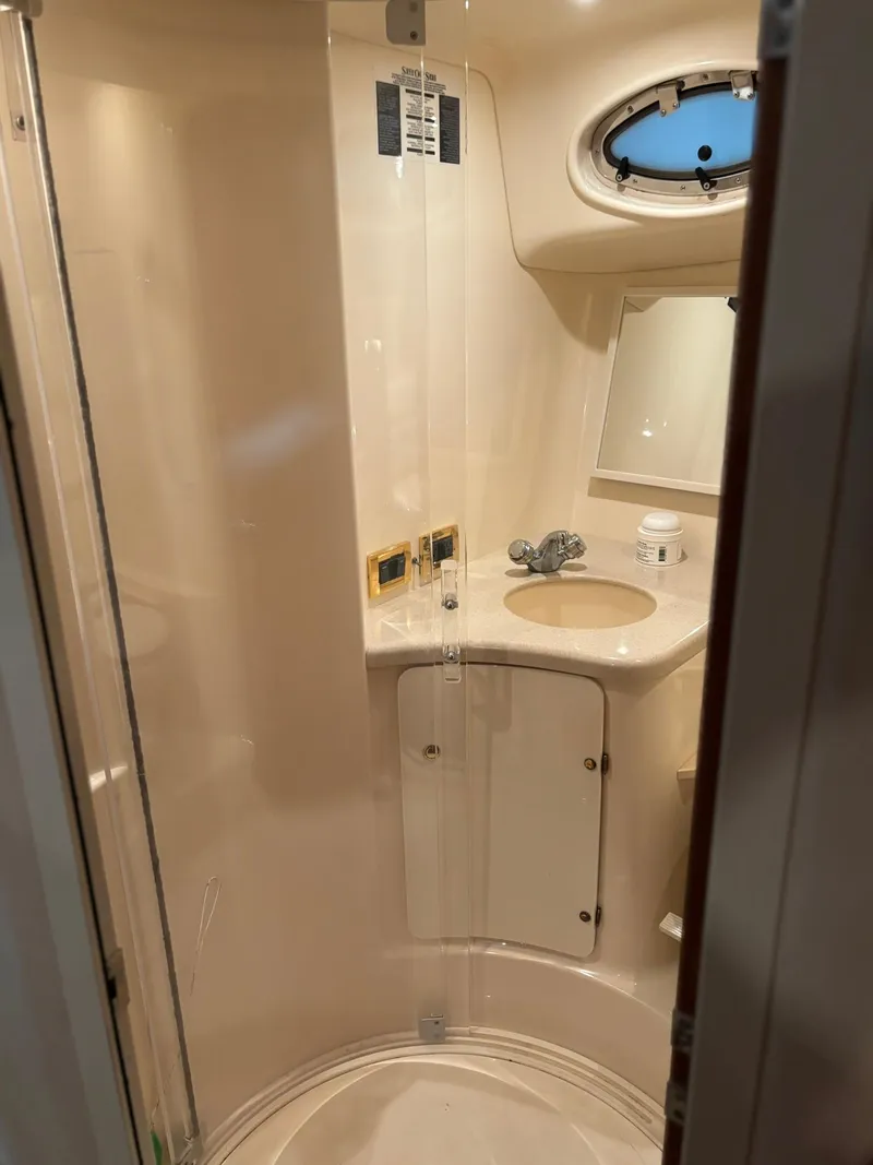 Slide: The Image of 1999 Sea Ray 370 Express Cruiser bathroom with sink, mirror, and porthole window. - 38