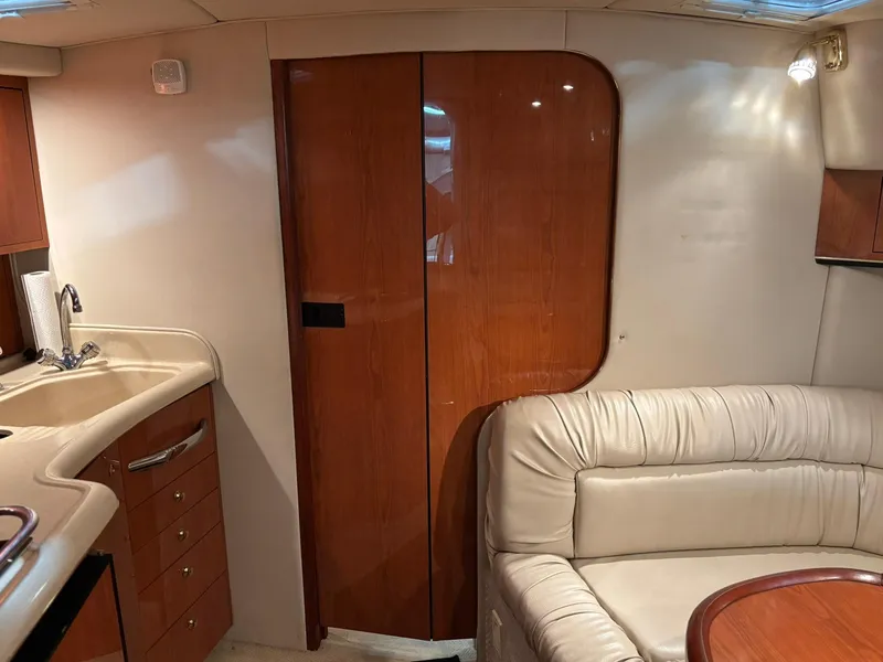 Slide: The Image of 1999 Sea Ray 370 Express Cruiser interior with wood cabinetry and beige leather seating. - 39