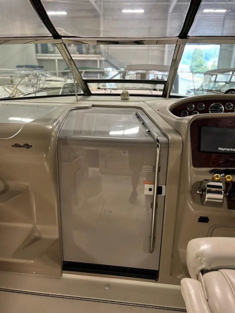Slide: The Image of 1999 Sea Ray 370 Express Cruiser helm with navigation equipment and cabin access. - 44