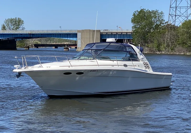 Slide: The Image of 1999 Sea Ray 370 Express Cruiser on a calm river near a bridge. - 5