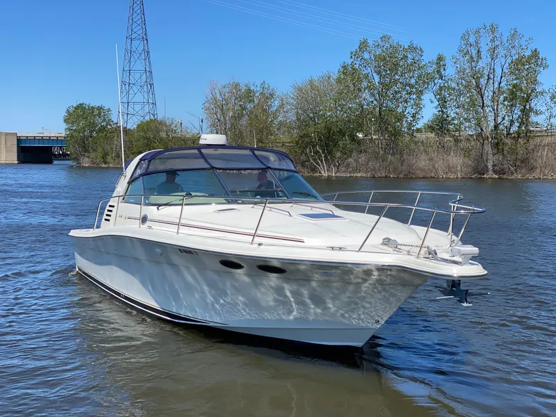 Slide: The Image of 1999 Sea Ray 370 Express Cruiser on a calm river with trees in the background. - 6