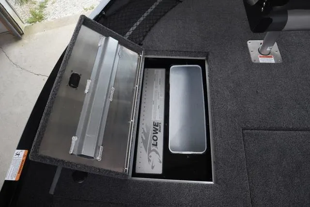 Slide: The Image of 2025 Lowe FM 1775 SC boat storage compartment with open lid, showcasing interior details. - 15