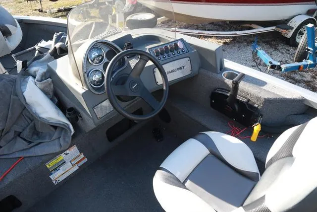 Slide: The Image of 2013 Alumacraft Navigator 165 CS boat interior with steering wheel and dashboard controls. - 12