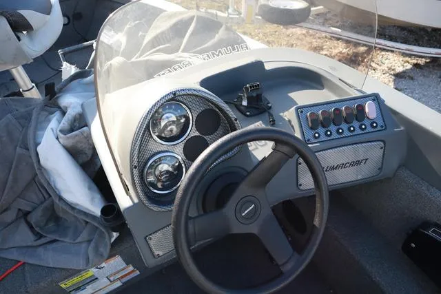 Slide: The Image of 2013 Alumacraft Navigator 165 CS boat dashboard with steering wheel and control panel. - 13
