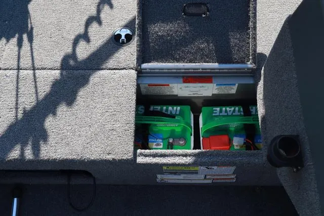 Slide: The Image of 2013 Alumacraft Navigator 165 CS boat battery compartment with two Interstate batteries. - 16