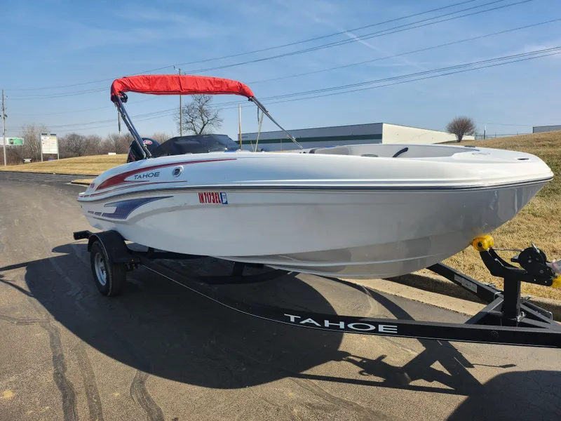 Slide: The Image of 2023 Tahoe T18 boat with red canopy on trailer, parked outdoors. - 5