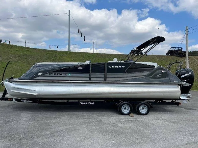 Slide: The Image of 2018 Crest Savannah 250 NX-L pontoon boat on trailer, parked outdoors. - 13