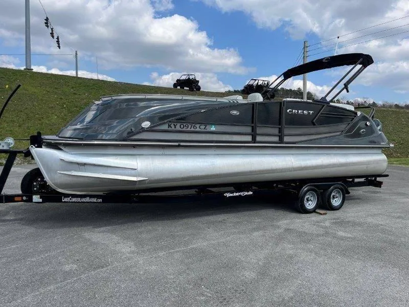 Slide: The Image of 2018 Crest Savannah 250 NX-L pontoon boat on trailer, parked outdoors. - 14