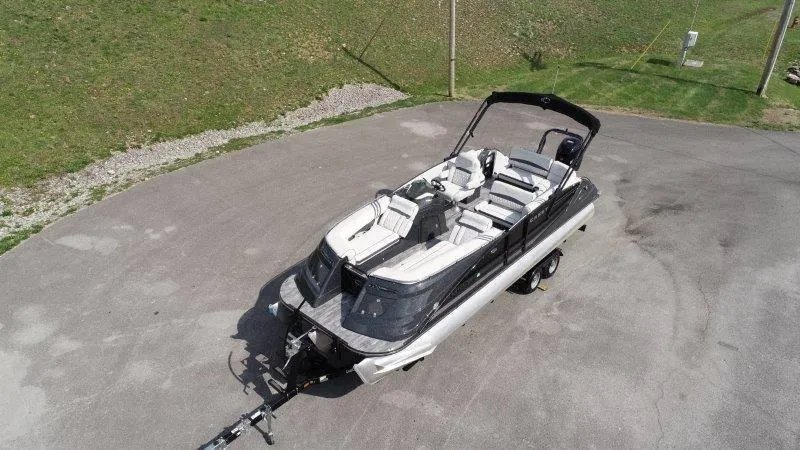 Slide: The Image of 2018 Crest Savannah 250 NX-L pontoon boat on trailer, parked on paved surface. - 2