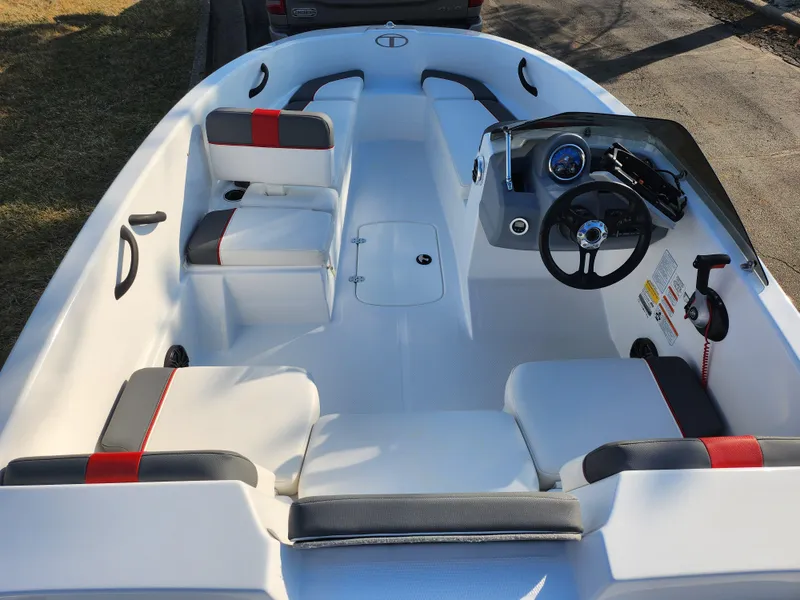 Slide: The Image of 2022 Tahoe T16 boat interior with white and red seating, steering console, and storage compartments. - 10