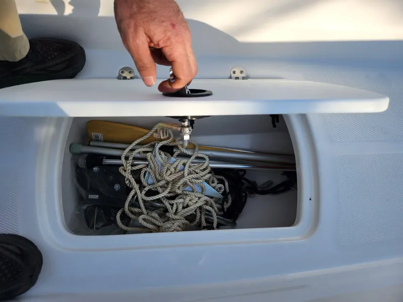 Slide: The Image of Storage compartment in a 2022 Tahoe T16 boat, containing ropes and equipment. - 12
