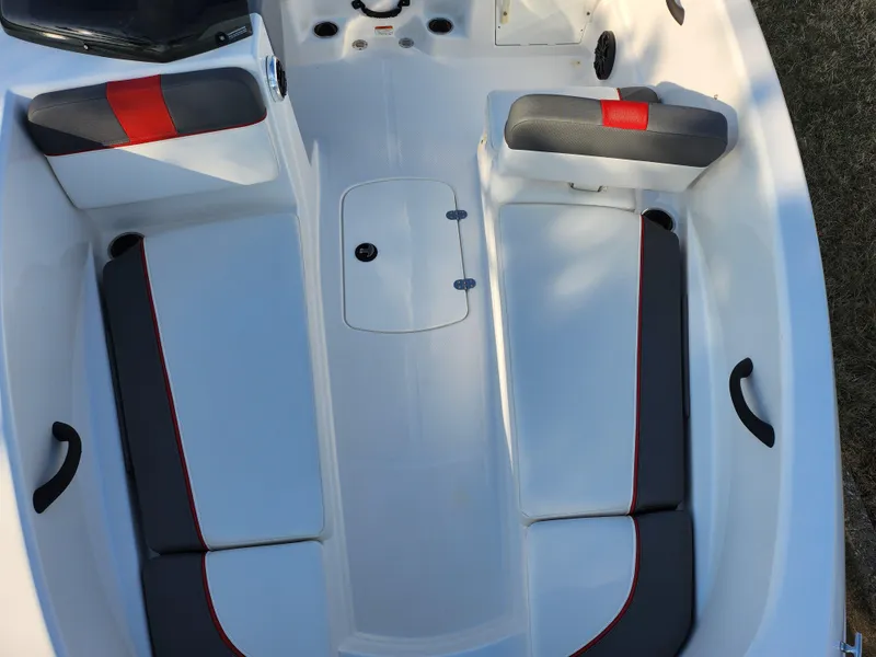 Slide: The Image of 2022 Tahoe T16 boat interior with gray and red seating, featuring storage compartments. - 16