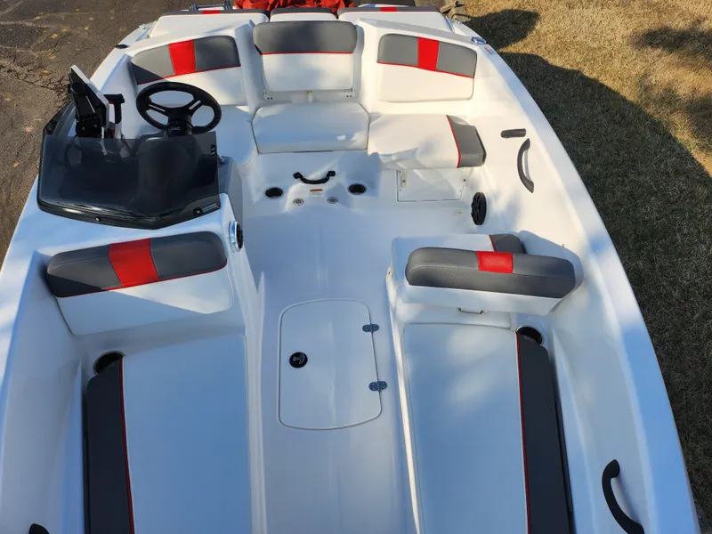Slide: The Image of 2022 Tahoe T16 boat interior with gray and red seating, steering console, and spacious layout. - 17