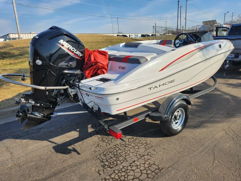 Slide: The Image of 2022 Tahoe T16 boat with Mercury engine on a trailer, parked outdoors. - 3