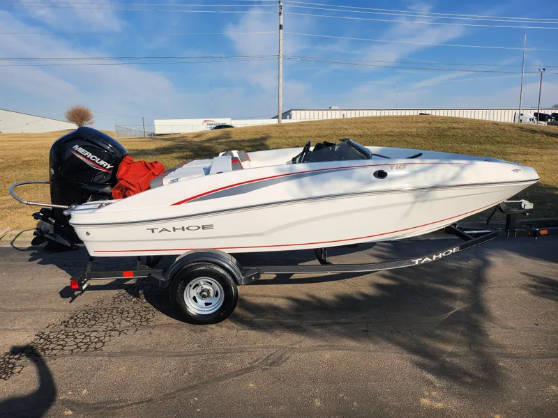 Slide: The Image of 2022 Tahoe T16 boat on trailer, white with red accents, parked outdoors. - 4