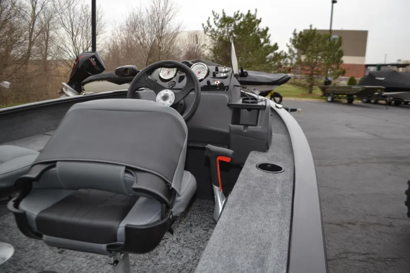 Slide: The Image of 2025 Tracker Super Guide V-16 SC boat interior with steering wheel and seating. - 2