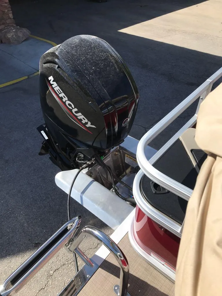 Slide: The Image of 2025 Sun Tracker Bass Buggy 18 DLX with Mercury outboard motor, docked outdoors. - 9