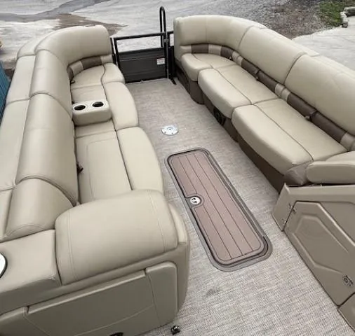 Slide: The Image of 2024 Regency 250 LE3 pontoon boat interior with beige seating and cup holders. - 10