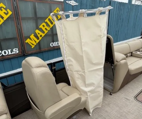 Slide: The Image of 2024 Regency 250 LE3 boat interior with privacy curtain and beige seating. - 19