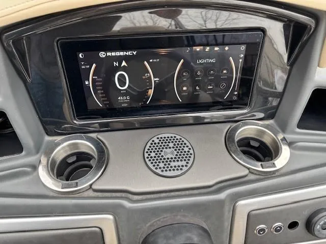 Slide: The Image of 2024 Regency 250 LE3 dashboard with digital display and cup holders. - 25