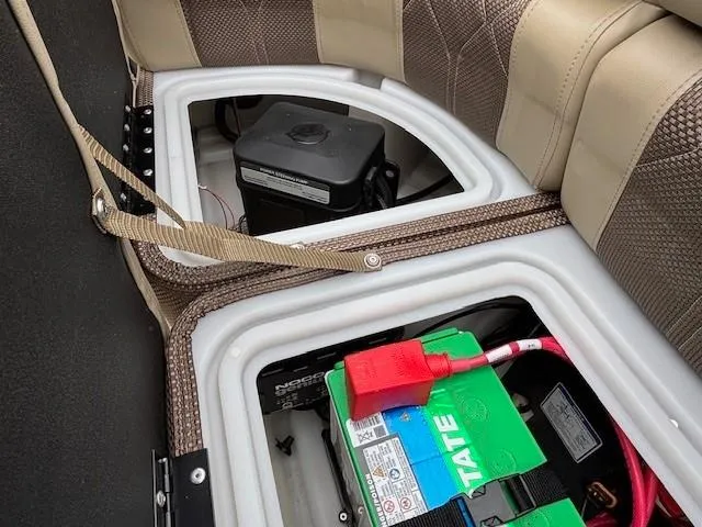 Slide: The Image of 2024 Regency 250 LE3 boat battery compartment with wiring and storage. - 38