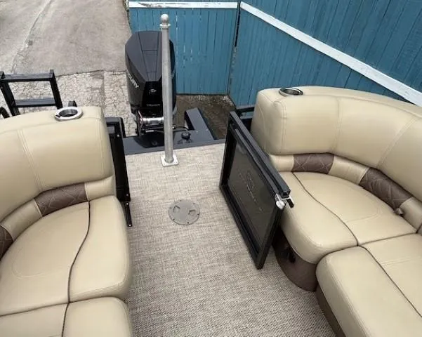 Slide: The Image of 2024 Regency 250 LE3 pontoon boat interior with beige seating and outboard motor. - 43