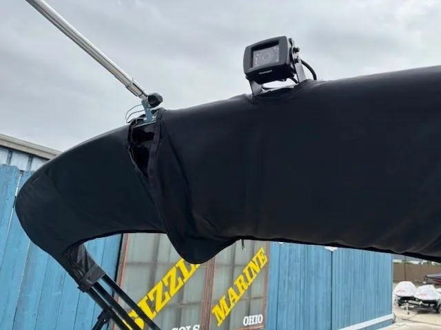 Slide: The Image of 2024 Regency 250 LE3 boat with black canopy and mounted camera. - 46