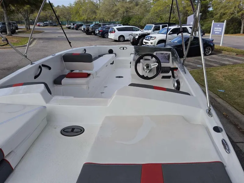 Slide: The Image of 2025 Tahoe T18 boat interior with seating and steering wheel in a parking lot. - 2