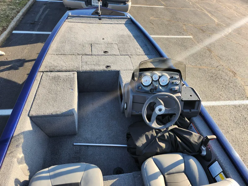 Slide: The Image of 2021 Tracker Pro 170 boat interior with steering console and seating in a parking lot. - 10