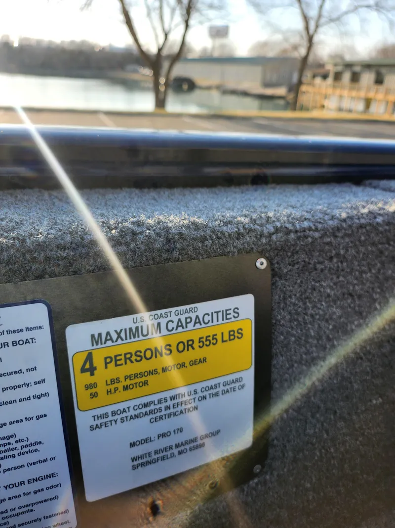 Slide: The Image of 2021 Tracker Pro 170 boat capacity label, maximum 4 persons or 555 lbs, near a lake. - 12