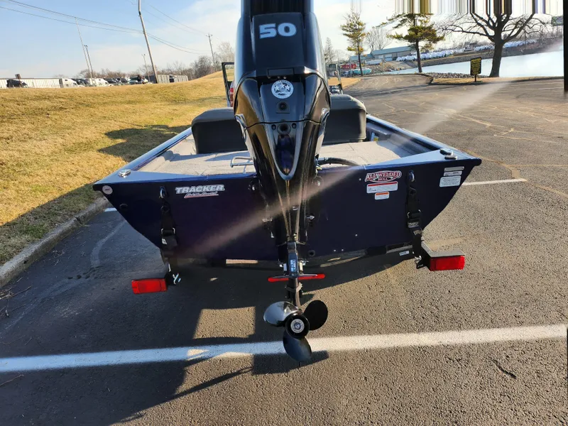 Slide: The Image of 2021 Tracker Pro 170 boat with 50 HP engine, parked on asphalt. - 2