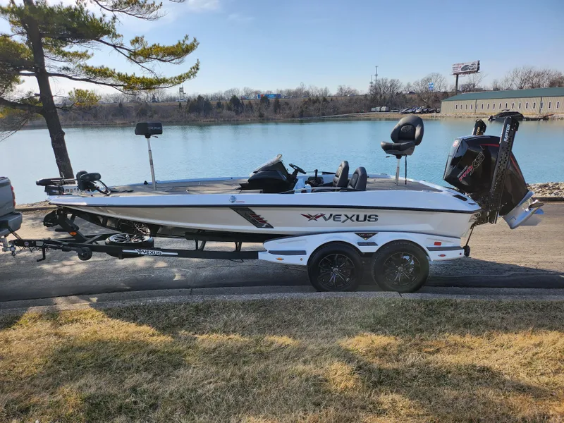 Slide: The Image of 2023 Vexus VX20 boat on trailer by a lake, under clear sky. - 10